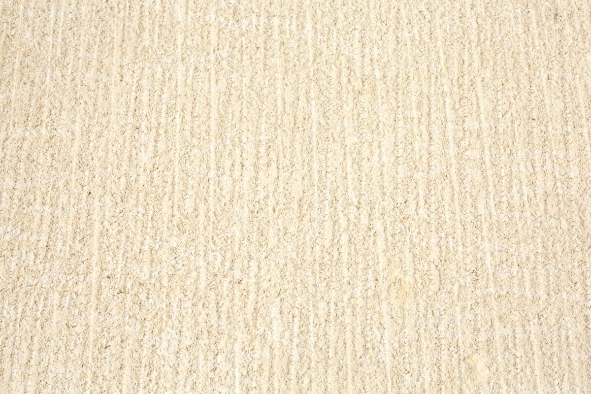 Close-up of a neutral cream high-pile wool rug texture