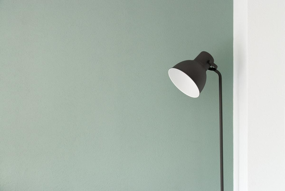 Slim black floor lamp lighting up a room corner