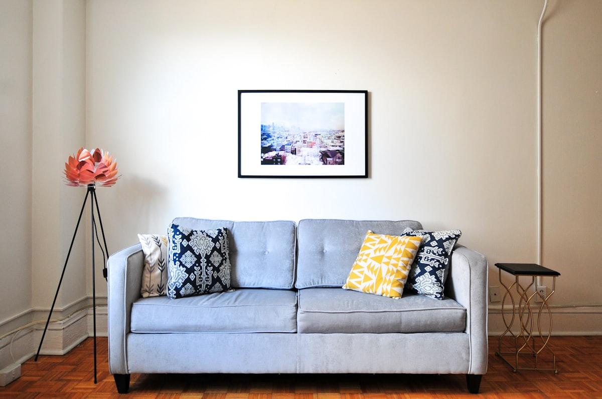 Compact grey sofa against a bright wall in a small living room