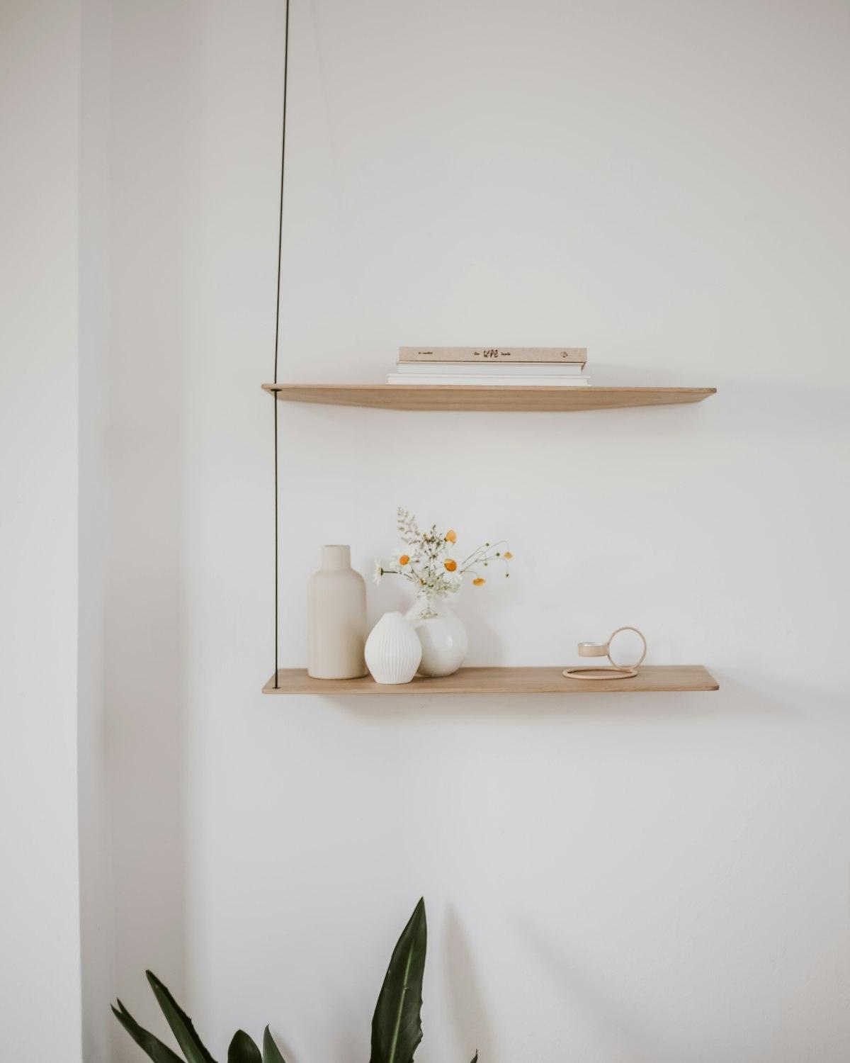 Floating wall shelves styled with vases, a book and dried flowers