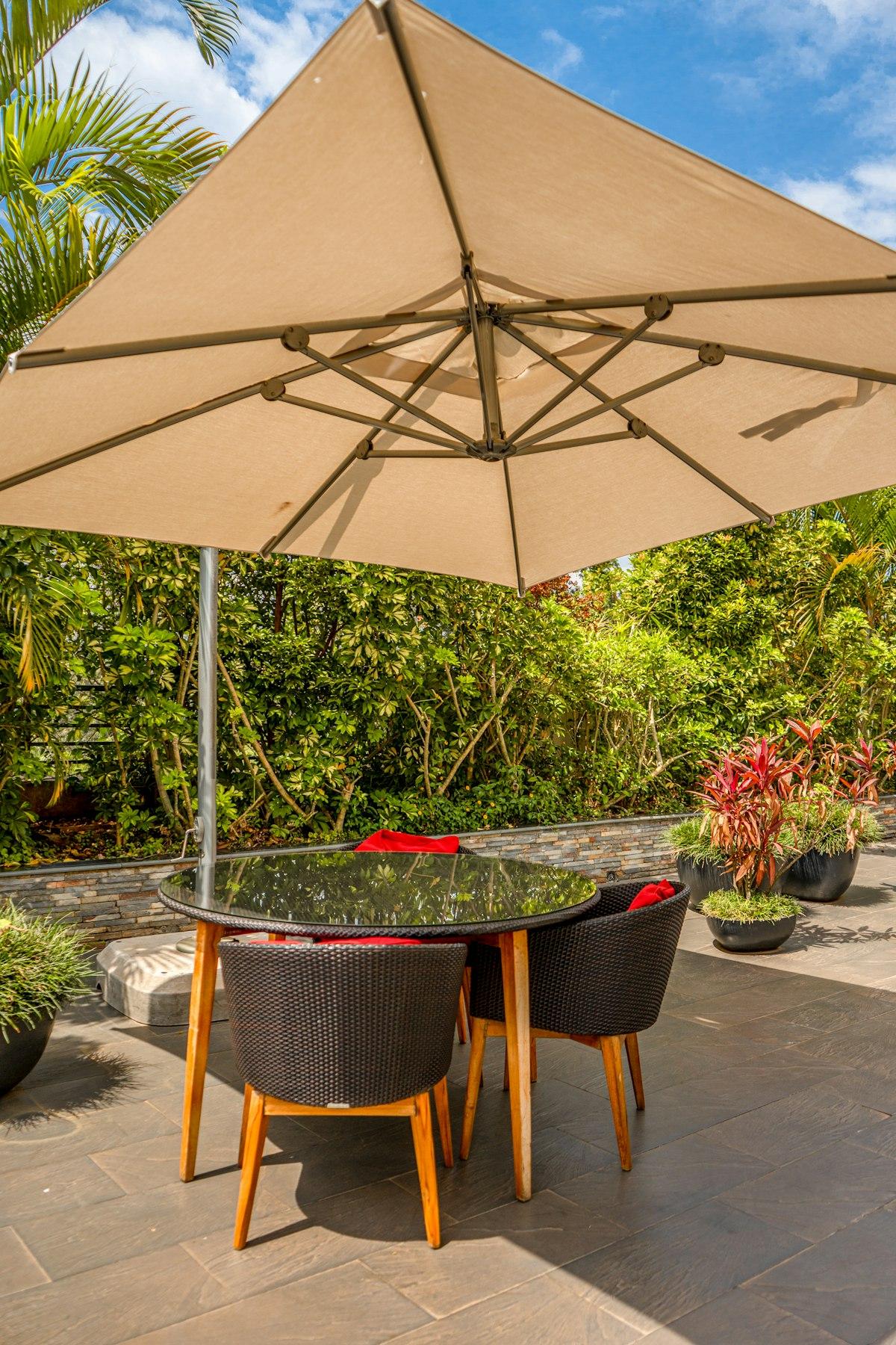 Offset cantilever parasol with its side pole shading an outdoor dining table