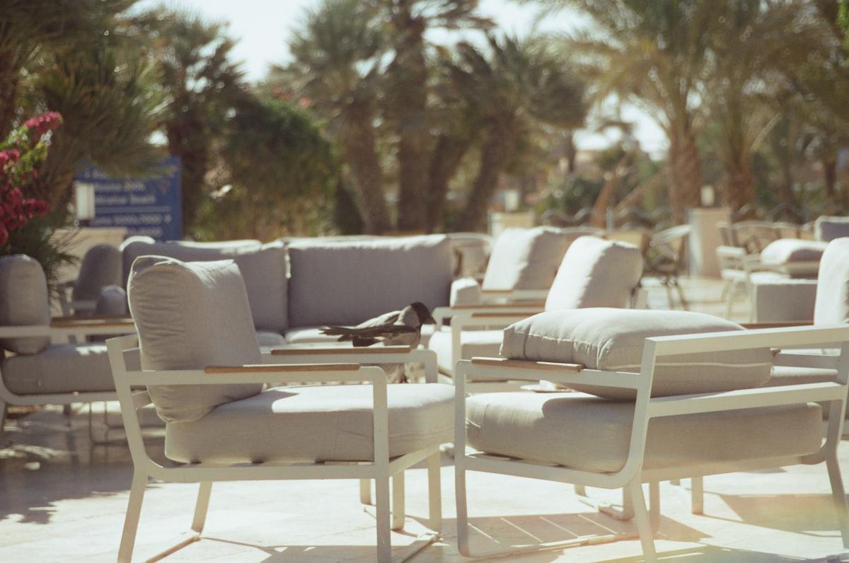 Sunlit outdoor armchairs with pale gray weather-resistant cushions