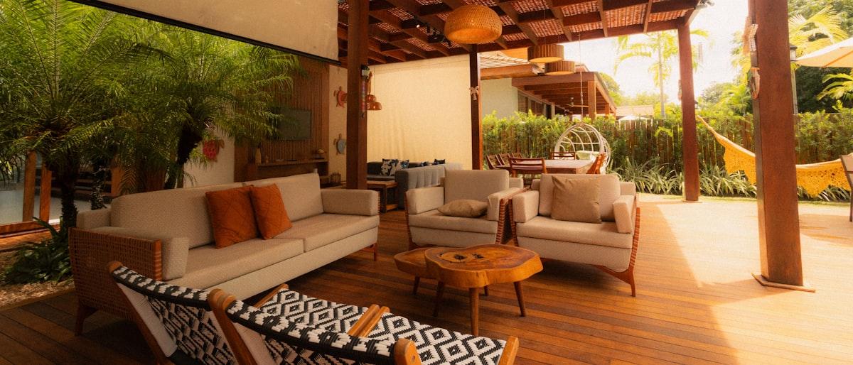 Low woven-frame outdoor sofa and armchairs on a wood deck terrace
