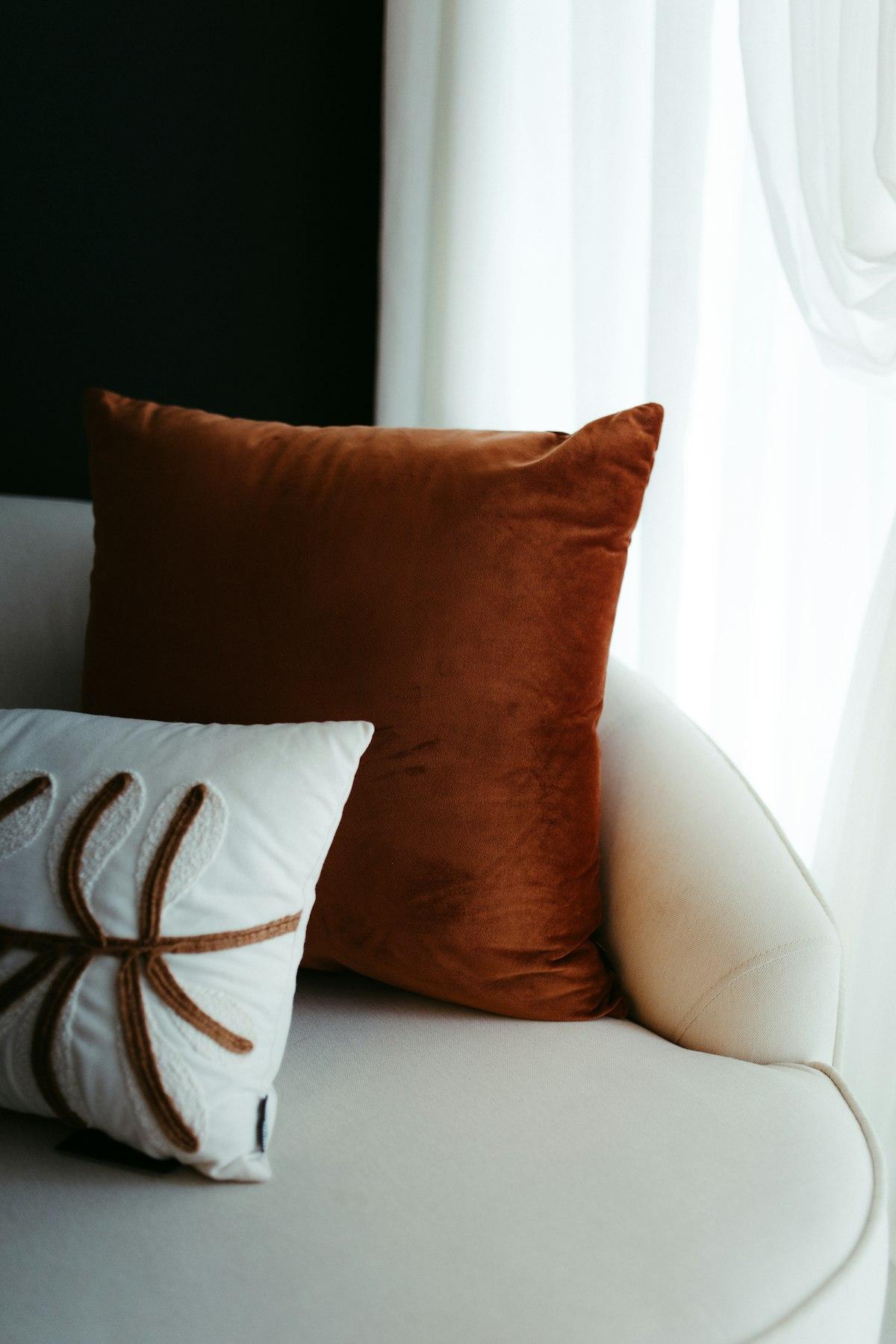 Rust terracotta velvet cushion on a cream sofa